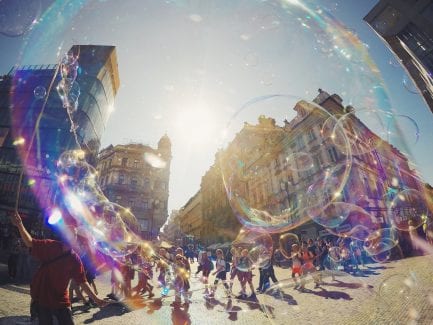City scene with bubbles in foreground and kids walking in background