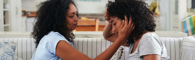 Mom comforting sad teenage daughter