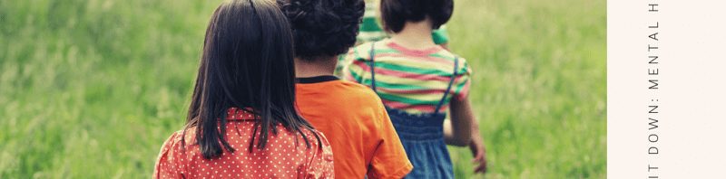 Young kids walking in a line into a green field