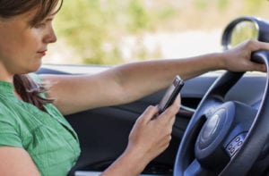 Woman driver reading a text message on a mobile