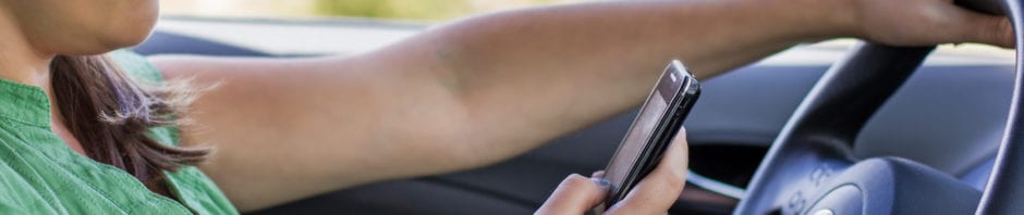 Woman driver reading a text message on a mobile