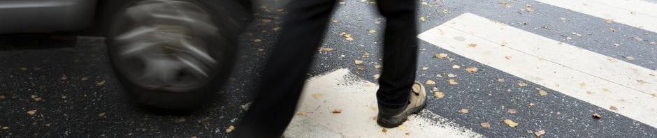 man crossing the street about to get hit by a car