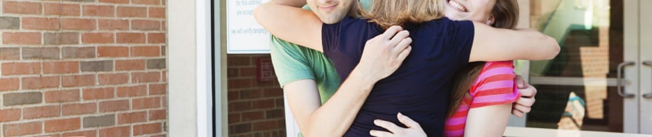 Kids leave home - Parents hugging goodbye their teenager